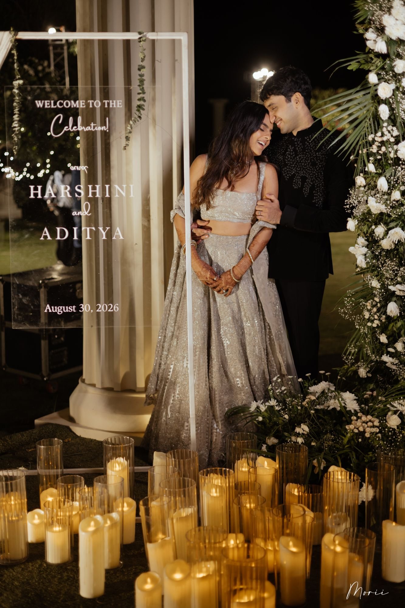 A couple by a candlelit welcome sign