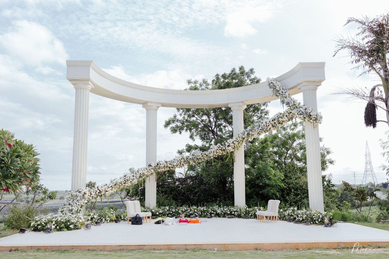A white pillared mandap under open sky
