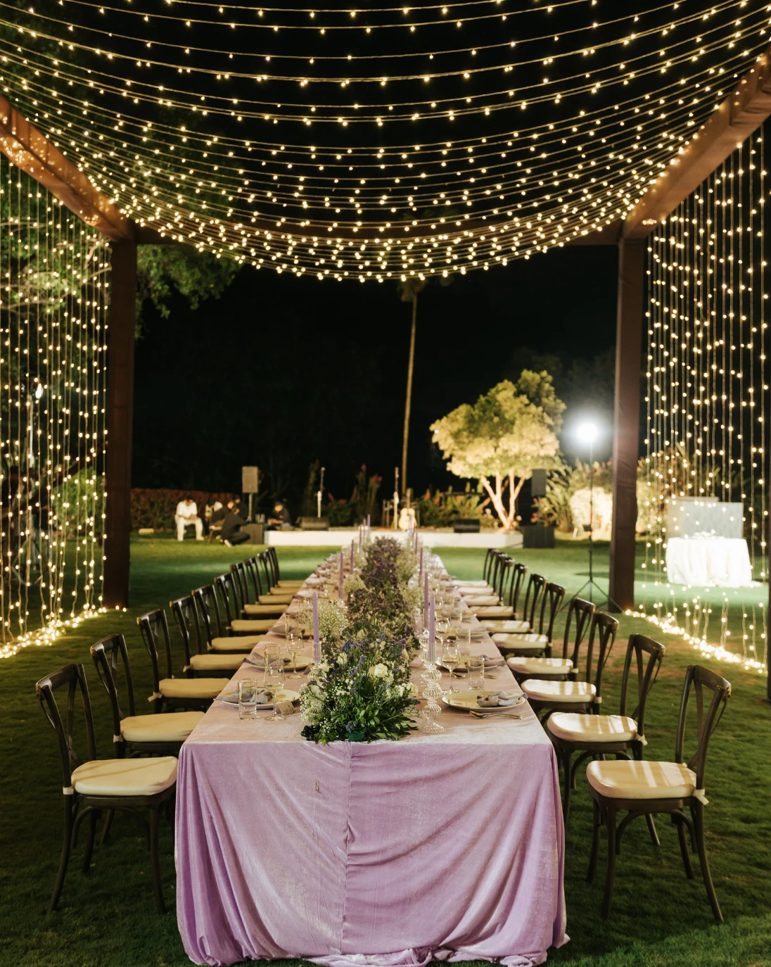 A long table under a canopy of fairy lights