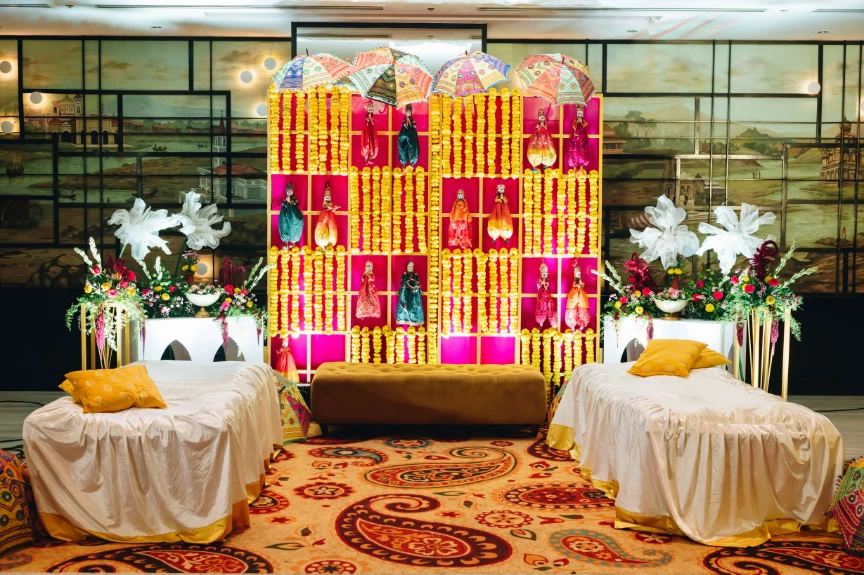 A mehendi backdrop in marigold and puppetry